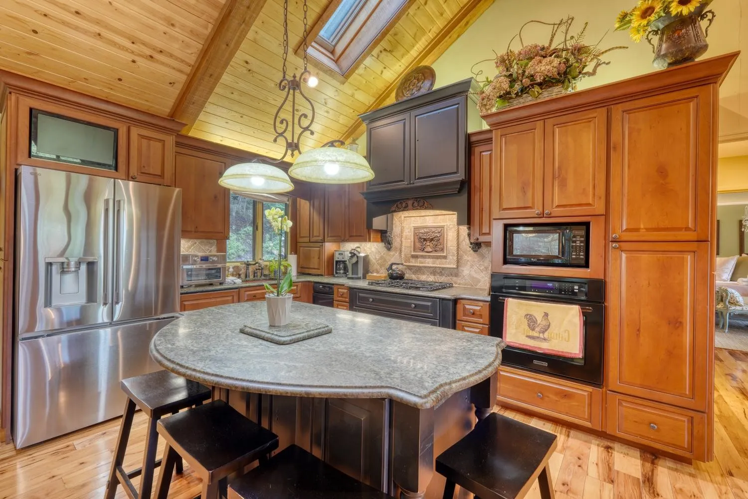 Kitchen with dark wood cabinetry, stainless appliances, and a barstool island
