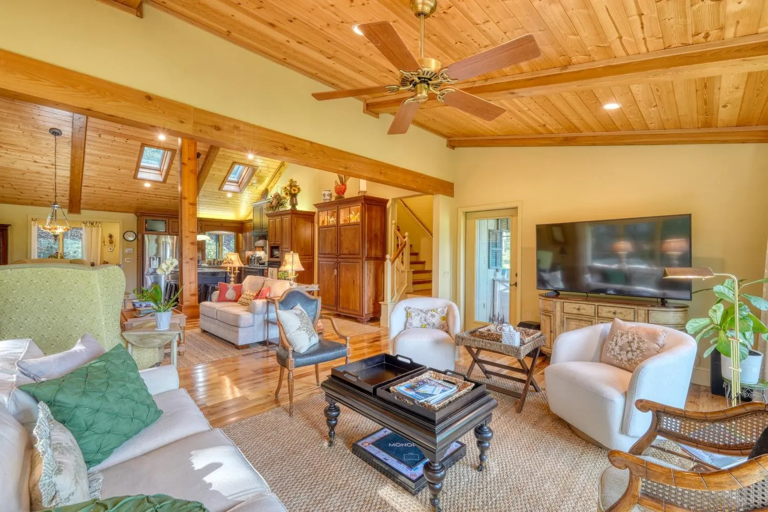 Family room with wood ceiling, sofas, and a stone fireplace